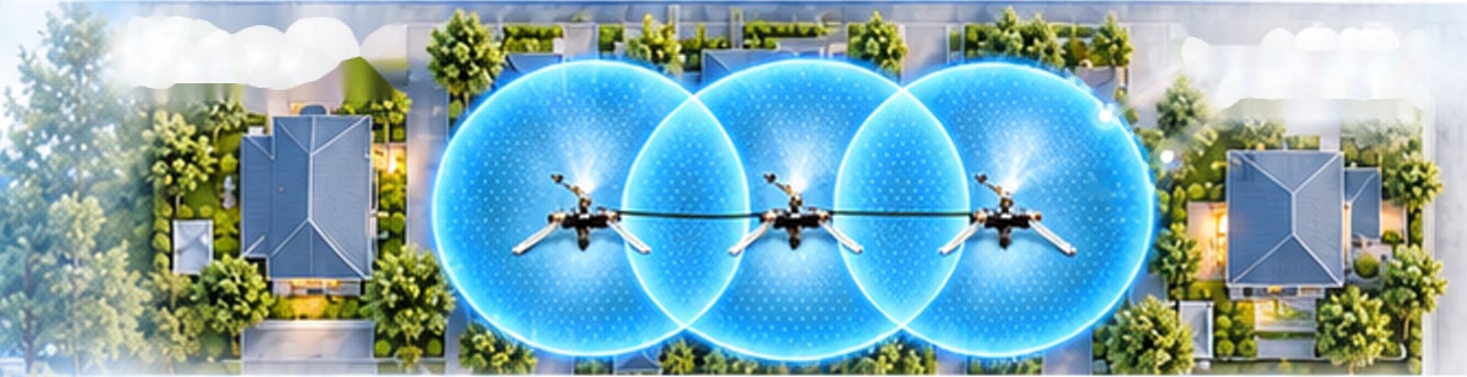 Top view: three FireBozz sprinklers in line, their circular vapour footprints overlapping above rooftops and gardens.